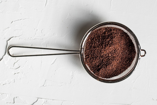 Free photo flat lay coffee powder in strainer