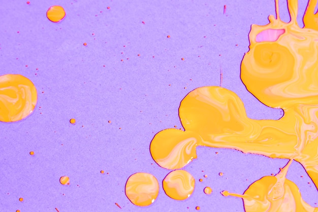 Flat lay composition with yellow paint on purple background