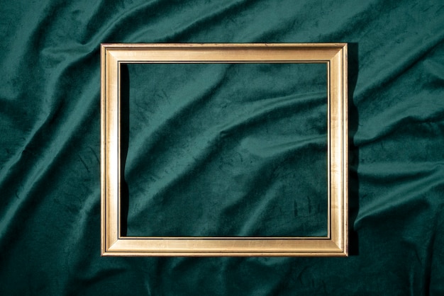 Free photo flat lay golden frame on green background