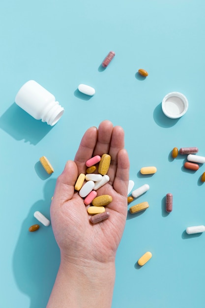 Free Photo flat lay of hand holding assortment of pills