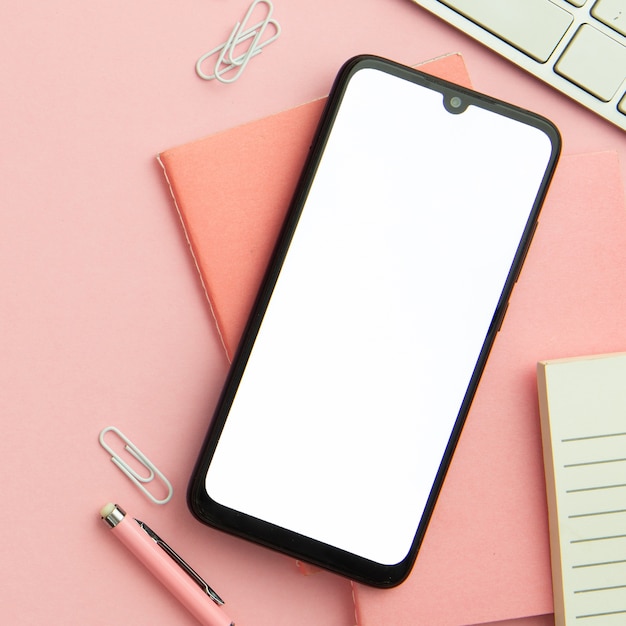 Free photo flat lay pink workplace arrangement with empty phone close-up