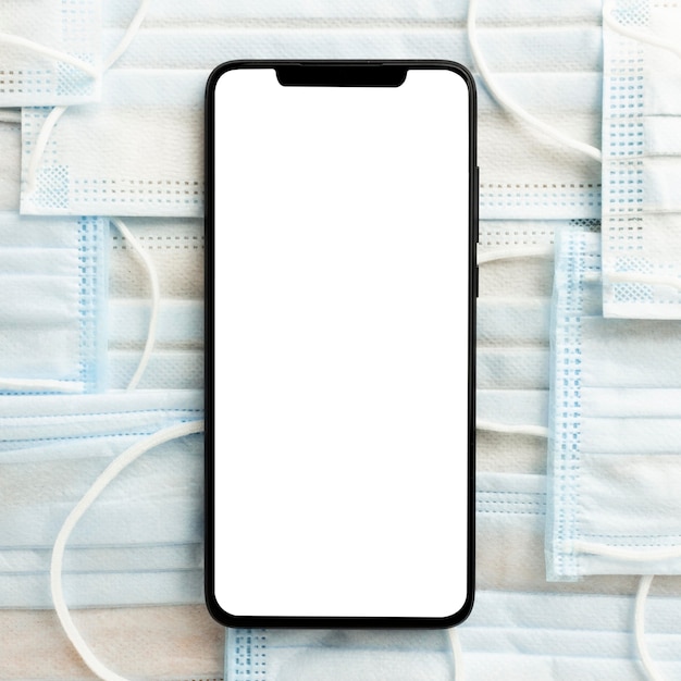 Free photo flat lay of smartphone on medical masks