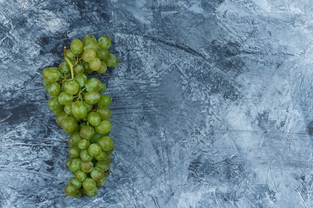 Free photo flat lay white grapes on dark blue marble background. horizontal