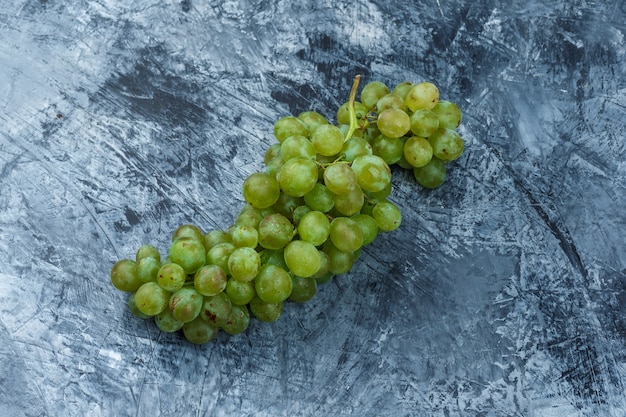 Free photo flat lay white grapes on dark blue marble background. horizontal