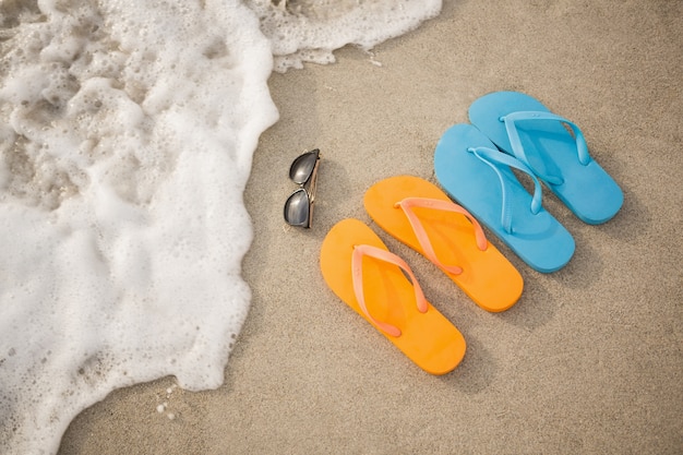 Free photo flip flops, sunglasses and starfish in sand