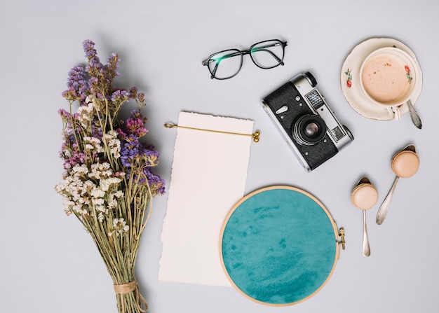 Free photo flowers bouquet with camera and coffee on light table