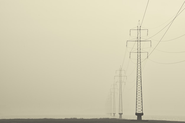 Free Photo foggy shot of transmission towers in the middle of a street