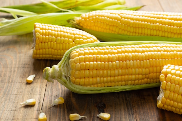 Free photo fresh corn on wooden table.