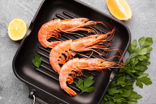 Free photo fresh shrimps on pan with condiments