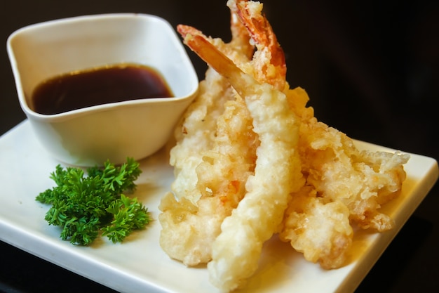 Free photo fried shrimps with greens garnish and sauce served on a white flat tray