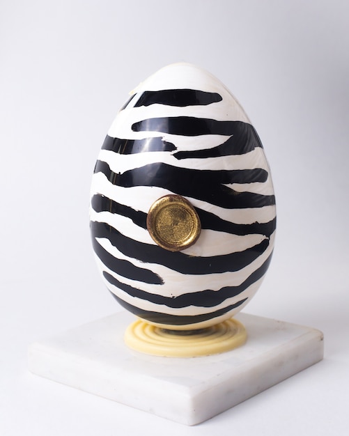 Free Photo front view chocolate egg in a zebra coloring black and white on stand