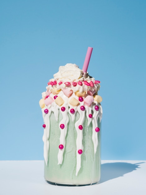 Free photo front view of delicious milkshake with blue background