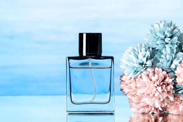 Free photo front view of elegant perfume colored flowers on light blue background