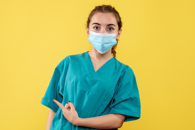 Free photo front view female doctor in medical shirt and mask, health virus covid-19 pandemic color uniform