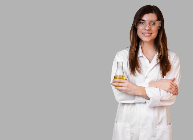 Free photo front view of female scientist with safety glasses holding test tube with copy space