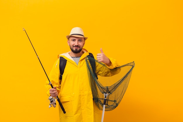 Foto gratuita vista frontale del pescatore che tiene rete e che dà i pollici in su