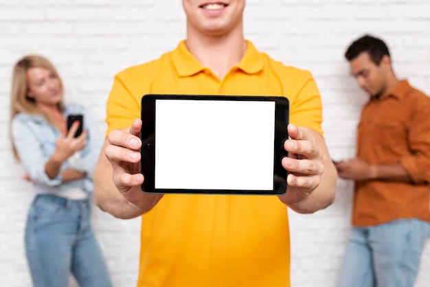 Free photo front view man holding a tablet with mock-up