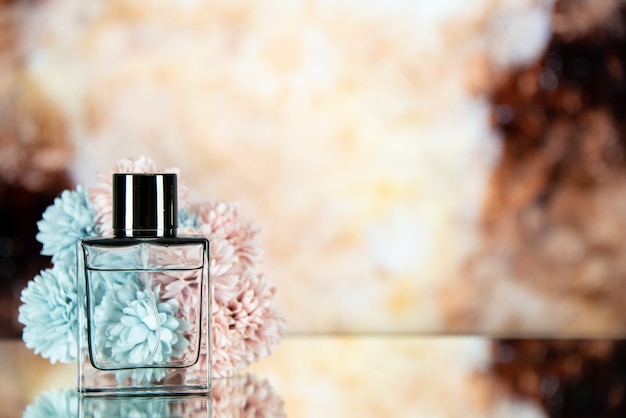 Free photo front view perfume bottle flowers on brown blurred background free space