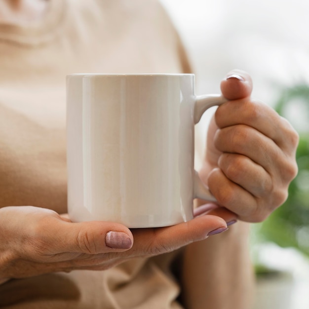 Free Photo front view of woman enjoying a drink in mug indoors