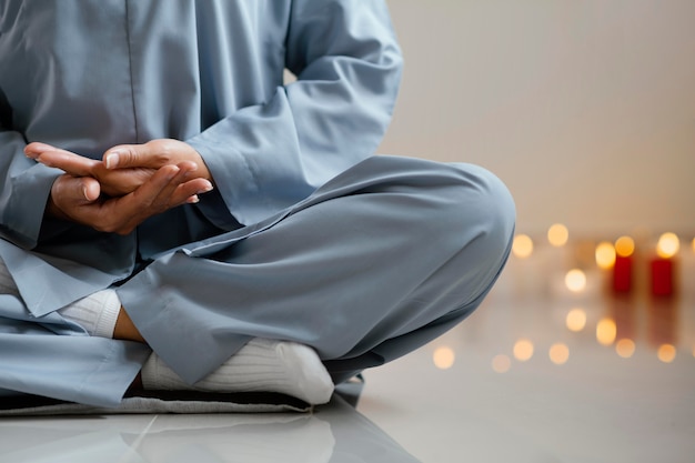 Free photo front view of woman meditating next to candles