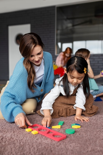 Free Photo full shot teacher helping girl learn