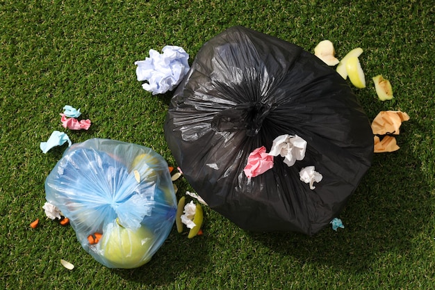 Free Photo garbage bags with rubbish on green background top view