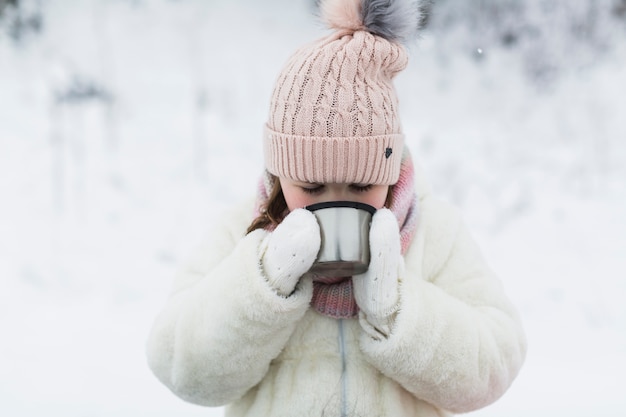 Free photo girl drinking from thermos cap