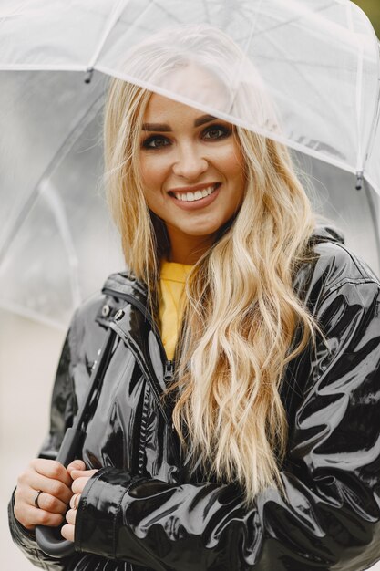 Girl walks. Woman in a black coat. Blonde with a umbrella.