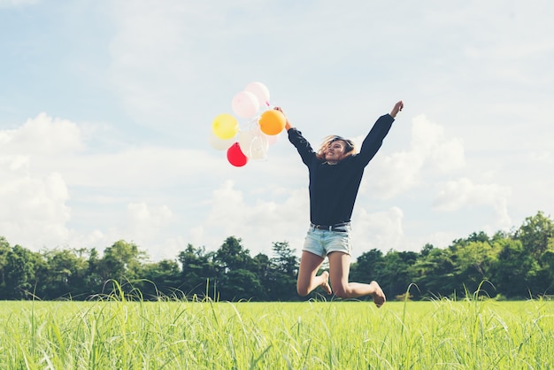 Free photo girl with colored balloons jumping