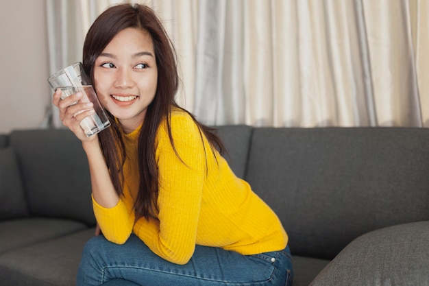 Free photo girl with a water glass next to her cheek