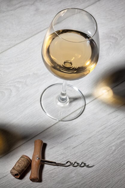 Free photo glass of white wine on wooden table top view