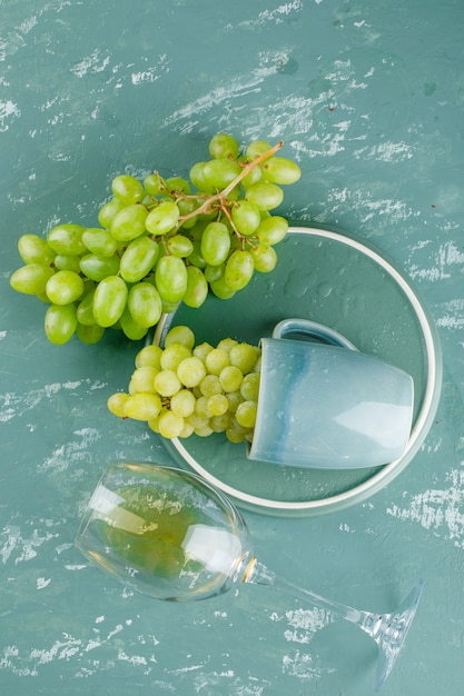 Free photo grapes in a cup with drink top view on plaster and tray background