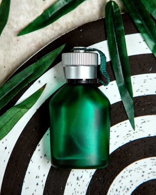 Free photo green bottle of parfum on the table