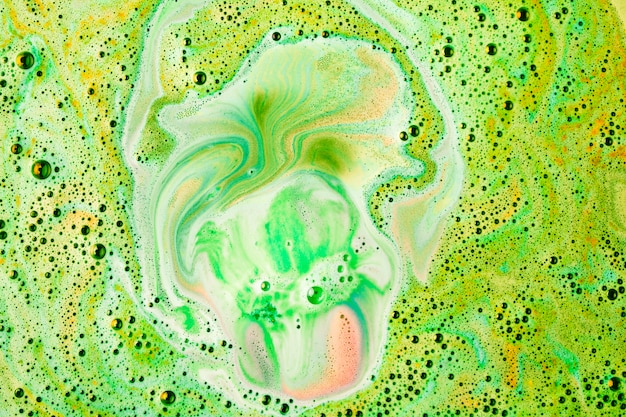 Free photo green colorful dissolve bath bomb in water