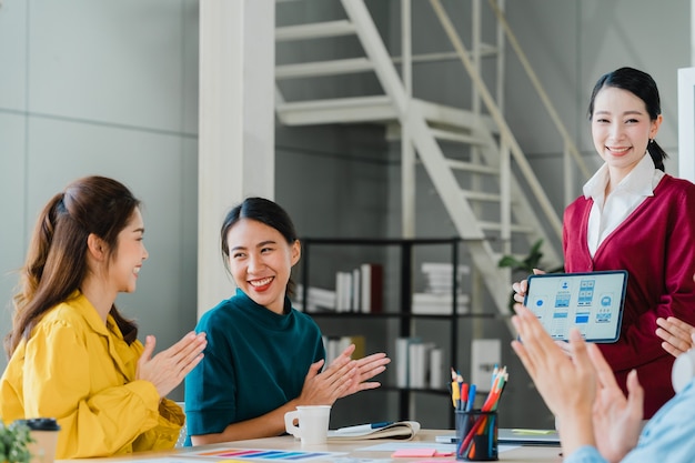 Free Photo group of asia young creative people in smart casual wear discussing business celebrate giving five after dealing feeling happy and signing contract or agreement in office. coworker teamwork concept.