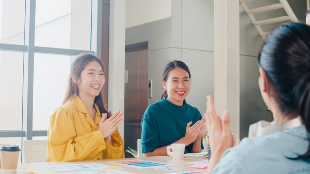 Free Photo group of asia young creative people in smart casual wear discussing business celebrate giving five after dealing feeling happy and signing contract or agreement in office. coworker teamwork concept.