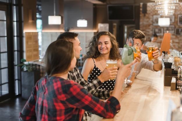 Free photo group of cheerful friends enjoying drinks in the pub