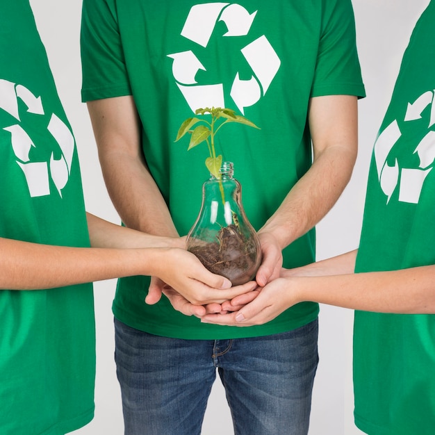 Free photo group of people holding plant in hands together