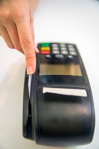 Free Photo hand swiping credit card in store. female hands with credit card and bank terminal. color image of a pos and credit cards.