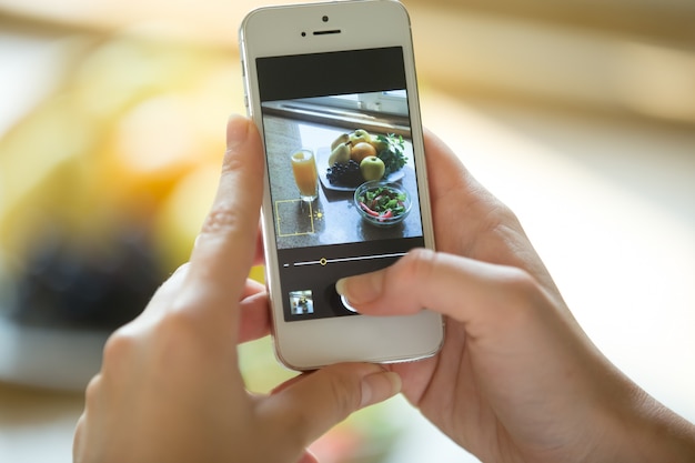 Free photo hands holding a phone with food picture on the screen