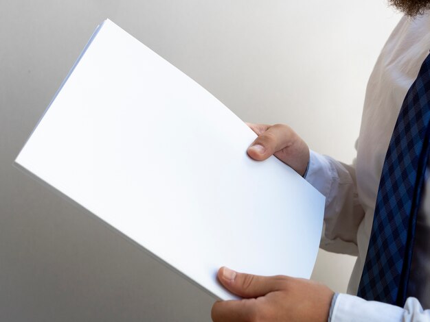 Hands holding a stack of paper mock-up