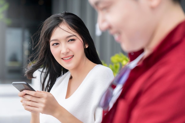 無料写真 幸せ陽気なアジアの若いカップルの男性と女性のアイコンタクト笑い一緒に笑顔楽しい会話リラックスカジュアルドレス世論調査と庭の休暇週末リゾートの背景