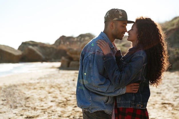 Free photo happy african loving couple hugging outdoors at beach