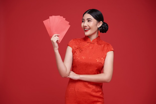 Free Photo happy chinese new year asian woman holding angpao or red packet monetary gift and gold ingot