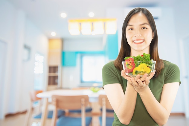 Foto gratuita materia di cucina felice della tenuta della signora sopra il fondo dello spazio della copia