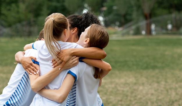 Free photo happy team hugging on field