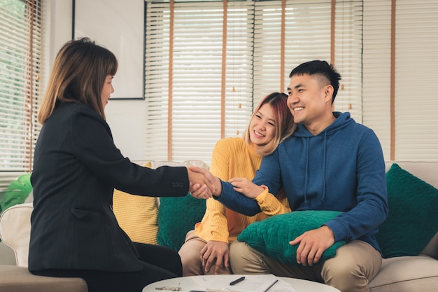 Free photo happy young asian couple and realtor agent