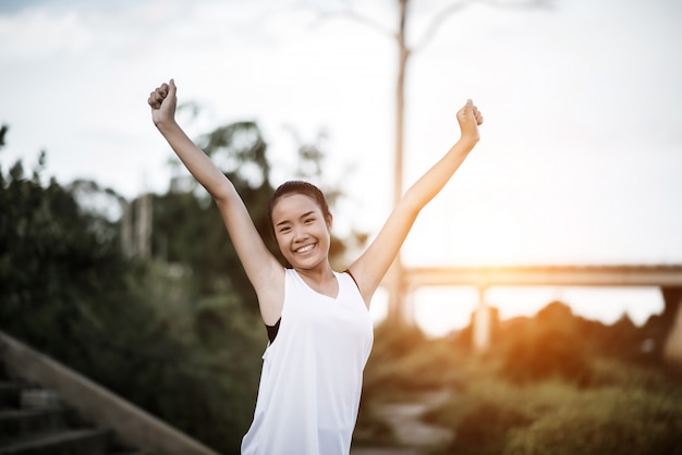 Free photo healthy young woman warming up outdoors workout before training session at the park.