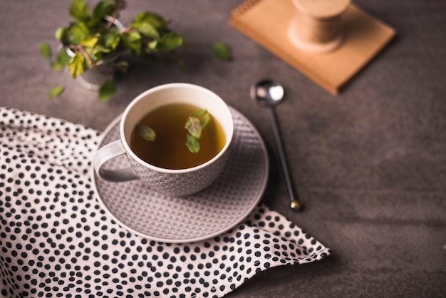 Free Photo herbal tea and polka dotted cloth on table