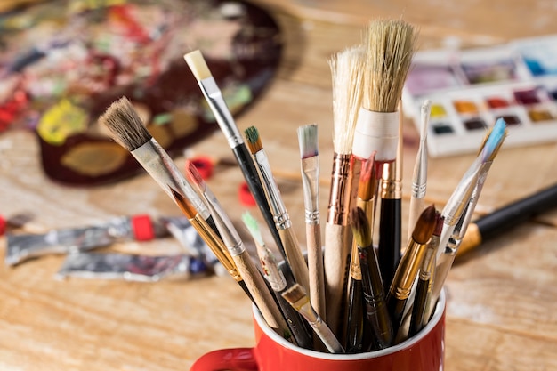 Free photo high angle of assortment of paint brushes in mug